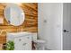 Modern bathroom with wooden accent wall, round mirror, and a stylish vanity at 255 Divide View Dr, Golden, CO 80403