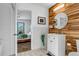 Bathroom with vanity sink, round mirror, and decorative wood accent wall with view to the bedroom at 255 Divide View Dr, Golden, CO 80403