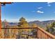 Mountain views from wood deck with a bistro set and custom metal chairs at 255 Divide View Dr, Golden, CO 80403