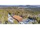 Aerial shot of a cabin surrounded by snow-covered trees with mountain views in the background at 255 Divide View Dr, Golden, CO 80403