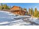 Exterior view of a wood-sided home with an expansive deck and snowy landscape at 255 Divide View Dr, Golden, CO 80403