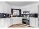 A bright kitchen featuring white cabinetry, quartz countertops, and modern appliances at 255 Divide View Dr, Golden, CO 80403
