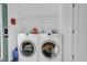 Bright laundry room featuring a full-size white washer and dryer and overhead shelf at 255 Divide View Dr, Golden, CO 80403