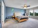 Blue bedroom featuring carpet, a ceiling fan, and a window with plenty of natural light at 9595 Elk Mountain Cir, Littleton, CO 80125