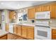 Bright kitchen with natural wood cabinets, white appliances, and modern faucet at 9595 Elk Mountain Cir, Littleton, CO 80125