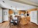 Open kitchen features wood floors, an island and eating area with a round table and four chairs at 9595 Elk Mountain Cir, Littleton, CO 80125