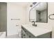 Bathroom featuring a modern vanity with stylish mirror and fixtures plus gray tiled tub at 8925 Oakwood St, Westminster, CO 80031