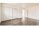 Bright bedroom featuring modern gray wood floors, large white closets, and an open doorway at 8925 Oakwood St, Westminster, CO 80031