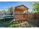 Cozy backyard shed with a charming porch, perfect for storage or a playhouse near a trampoline at 2080 E 84Th Ave, Denver, CO 80229
