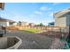 Landscaped backyard with a small grass area and gravel section surrounded by a wood fence and homes at 3074 Kestrel St, Brighton, CO 80601