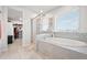 Relaxing bathroom boasts a soaking tub and glass-enclosed shower, complemented by a spacious walk-in closet at 3074 Kestrel St, Brighton, CO 80601