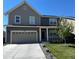 Charming two-story home featuring a gray exterior, a two-car garage, and a well-maintained front yard at 3074 Kestrel St, Brighton, CO 80601