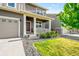 Welcoming front porch with white columns, a cozy seating area, and lovely landscaping at 3074 Kestrel St, Brighton, CO 80601