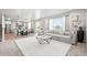 Open-concept living room with a large sectional sofa, stylish coffee table, and plenty of natural light at 3074 Kestrel St, Brighton, CO 80601