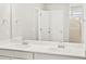 Bright bathroom with double sinks, modern fixtures, and a view of the shower at 17120 E 90Th Pl, Commerce City, CO 80022