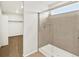 Modern bathroom featuring a glass-enclosed shower with tan tile and neutral-colored flooring at 17120 E 90Th Pl, Commerce City, CO 80022