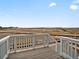 Outdoor deck with white railing overlooking open field with clear blue sky at 17120 E 90Th Pl, Commerce City, CO 80022