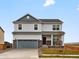 Two-story home with gray siding, gray roof, attached garage, and well-kept lawn at 17120 E 90Th Pl, Commerce City, CO 80022