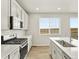 This kitchen has stainless steel appliances, a subway tile backsplash, and modern white cabinets at 17120 E 90Th Pl, Commerce City, CO 80022