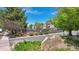 Landscaped entrance to the Hunt Club community with mature trees, greenery, and community tennis courts at 1470 S Quebec Way # 83, Denver, CO 80231