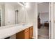 Bathroom vanity with updated fixtures next to the door with a glimpse of the bedroom in the background at 9615 Lansing Cir, Commerce City, CO 80022