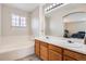 Bright bathroom featuring a double vanity, soaking tub, and a large mirror that brings depth to the space at 9615 Lansing Cir, Commerce City, CO 80022