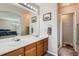 Bathroom featuring a double vanity with framed mirrors and a glass-enclosed shower with a neutral color palette at 9615 Lansing Cir, Commerce City, CO 80022