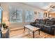 Cozy living room featuring hardwood floors, large windows, and view into the kitchen at 9615 Lansing Cir, Commerce City, CO 80022