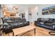 Open living room with hardwood floors, mountain view art, and kitchen access at 9615 Lansing Cir, Commerce City, CO 80022