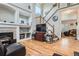 Living room featuring a fireplace, high ceilings, hardwood floors, and a staircase at 9615 Lansing Cir, Commerce City, CO 80022