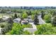Aerial view of a charming home with mature trees, a well-manicured lawn, and nearby city views at 5071 S Boston St, Greenwood Village, CO 80111
