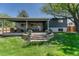 A beautiful backyard with a covered patio, a well-maintained lawn, and mature landscaping at 5071 S Boston St, Greenwood Village, CO 80111