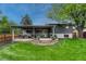 Inviting backyard featuring a covered patio with stylish seating and a well-manicured lawn, perfect for outdoor living and entertaining at 5071 S Boston St, Greenwood Village, CO 80111