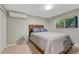 Cozy bedroom featuring a comfortable bed, neutral carpet and walls, and a bright window at 5071 S Boston St, Greenwood Village, CO 80111
