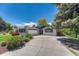 A bright ranch-style home with an attached garage and ample parking on a sunny day at 5071 S Boston St, Greenwood Village, CO 80111