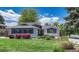Charming single-Gathering home with light brick, lush landscaping, and mature trees under a partly cloudy blue sky at 5071 S Boston St, Greenwood Village, CO 80111