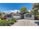 Attractive home showcasing a two-car garage and an inviting driveway with beautiful, mature landscaping at 5071 S Boston St, Greenwood Village, CO 80111