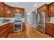 Modern kitchen with stainless steel appliances, wood cabinets, and hardwood floors, perfect for culinary enthusiasts at 5071 S Boston St, Greenwood Village, CO 80111