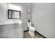 Bathroom with a framed mirror, modern vanity, commode, tasteful decorations, and light gray walls at 11680 Imboden Rd, Hudson, CO 80642