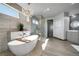 Bright bathroom features a modern chandelier, soaking tub, glass shower, and elegant tile work at 11680 Imboden Rd, Hudson, CO 80642