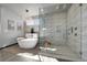 Bright bathroom featuring a modern chandelier, glass shower, soaker tub, and textured backsplash at 11680 Imboden Rd, Hudson, CO 80642
