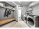 Convenient mudroom with washer, dryer, bench, and storage shelves for easy organization at 11680 Imboden Rd, Hudson, CO 80642