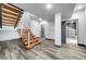 Modern staircase with floating wood steps, stainless steel railings, and a view into the bathroom at 11680 Imboden Rd, Hudson, CO 80642