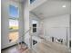 Bright stairwell with stainless steel railings, wood stairs, pendant lighting, and large windows offering picturesque outdoor views at 11680 Imboden Rd, Hudson, CO 80642