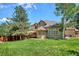Beautifully landscaped backyard with lush greenery, a deck, and a charming home exterior at 5331 S Geneva Way, Englewood, CO 80111