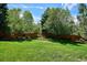 Expansive backyard featuring lush green grass, mature trees, and a privacy fence at 5331 S Geneva Way, Englewood, CO 80111