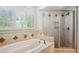 Bright bathroom with a soaking tub, window, and glass-enclosed shower at 5331 S Geneva Way, Englewood, CO 80111