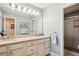 Well-lit bathroom featuring double sinks, a large mirror, and a tiled shower at 5331 S Geneva Way, Englewood, CO 80111