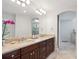 Elegant bathroom with double sinks, dark wood cabinets, and an arched mirror at 5331 S Geneva Way, Englewood, CO 80111