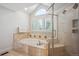 Bright bathroom with a soaking tub, window, and glass-enclosed shower at 5331 S Geneva Way, Englewood, CO 80111